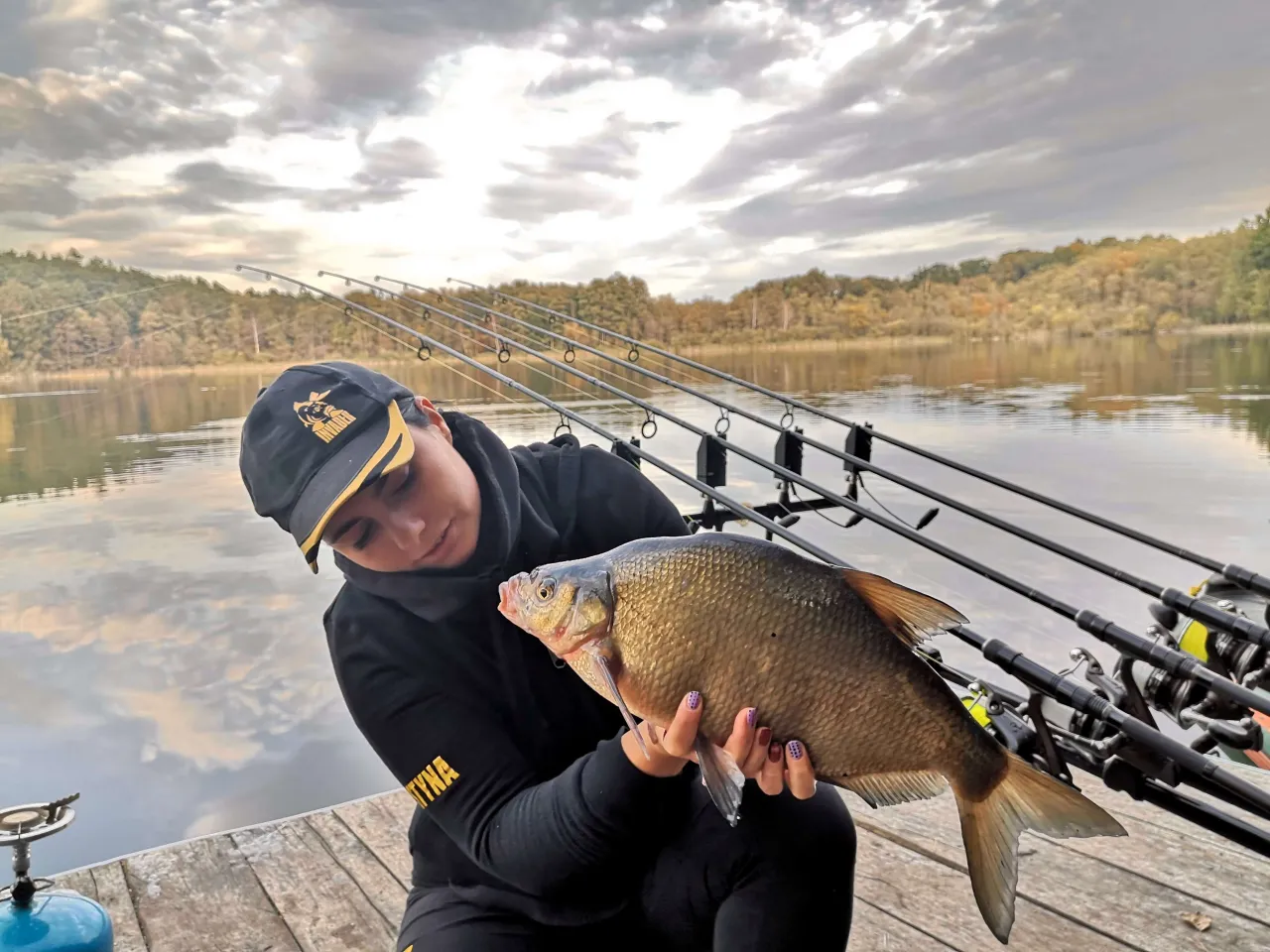 Kobieta trzyma złowionego leszcza. Kozieradka na jakie ryby? Na leszcze, które lubią jej zapach.