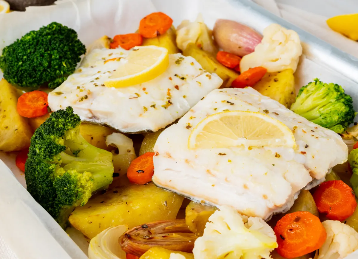Pyszna ryba z pieczonymi warzywami: ziemniakami, brokułami, marchewką i kalafiorem. Idealne co do ryby na obiad!