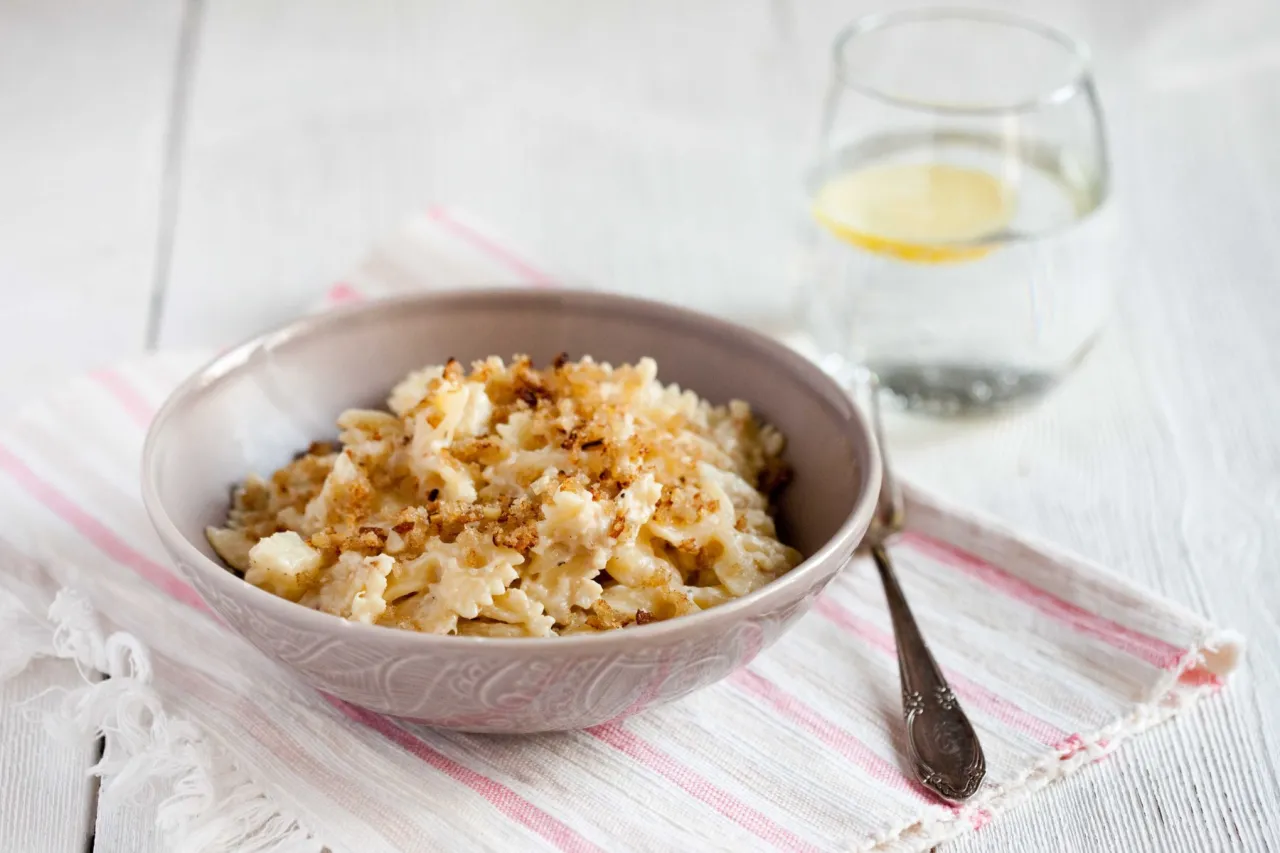 Pyszny makaron z kalafiorem w sosie śmietanowym, posypany chrupiącą panierką. Idealny na obiad.