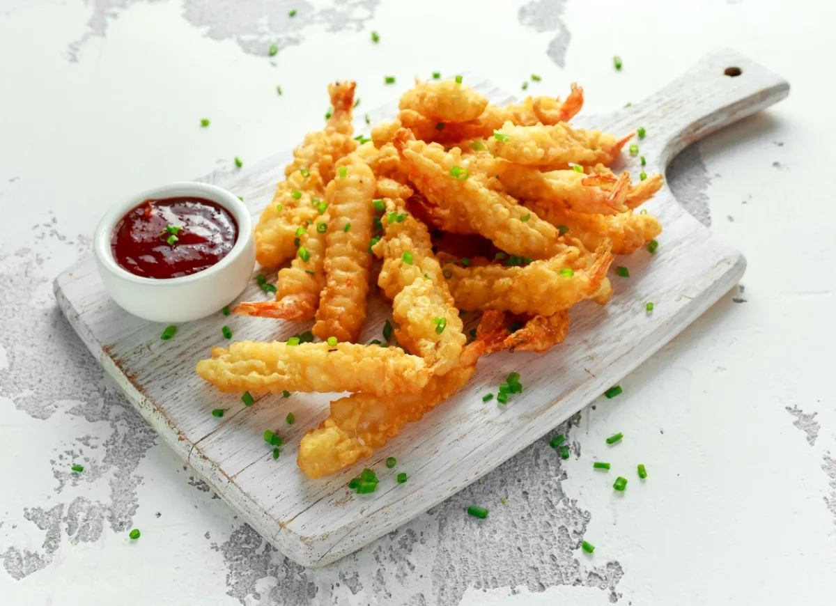 Chrupiące krewetki w panierce, podane z sosem. Idealna przekąska, która zachwyci każdego miłośnika owoców morza.