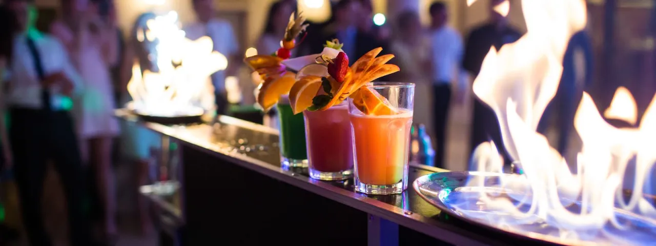 Barman na weselu przygotowujący kolorowe drinki