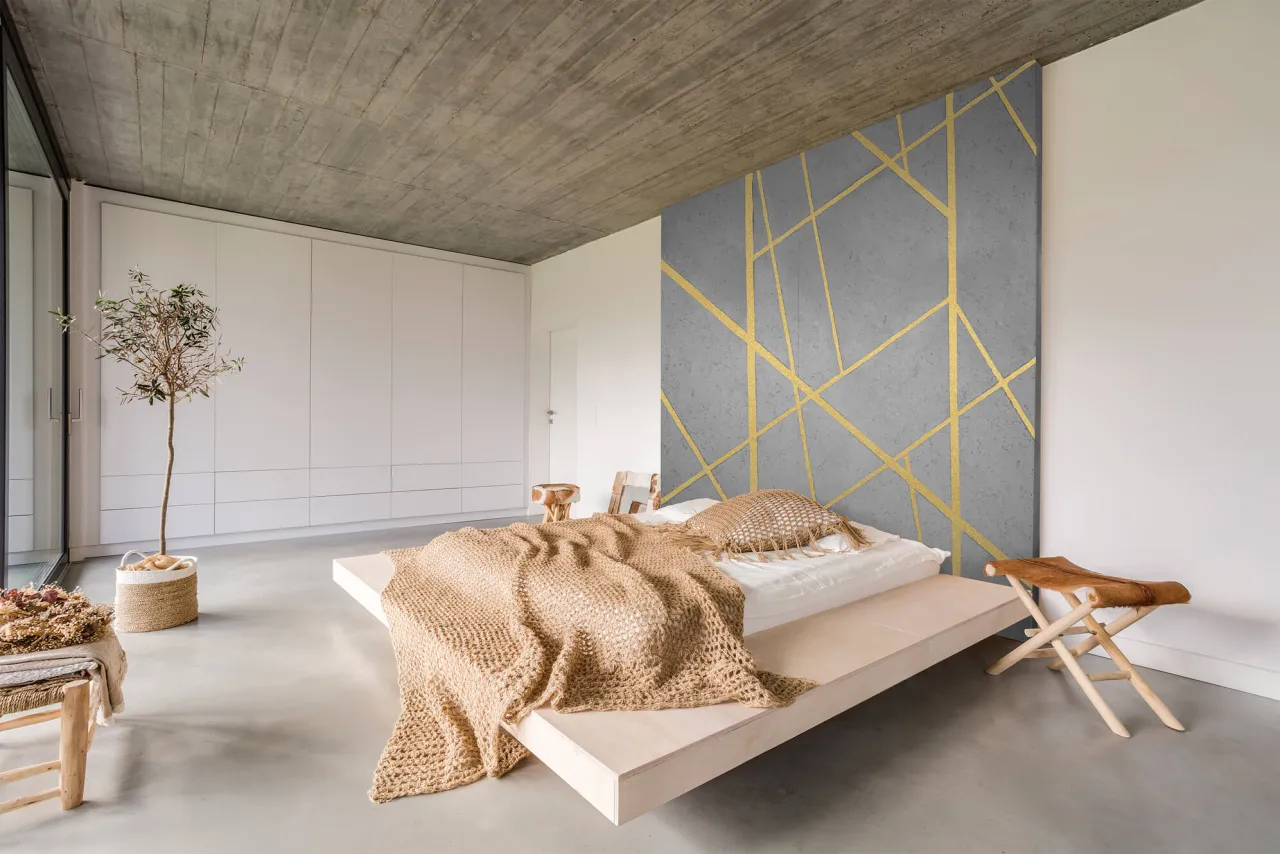 Ściana z betonem dekoracyjnym i złotymi liniami, inspiracja jak zrobić beton dekoracyjny na ścianie. Minimalistyczna sypialnia.