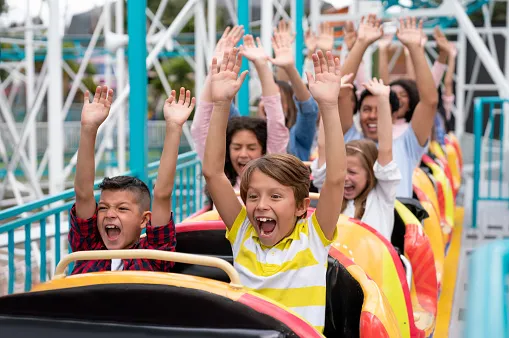 szczęśliwa rodzina w parku rozrywki na rollercoasterze