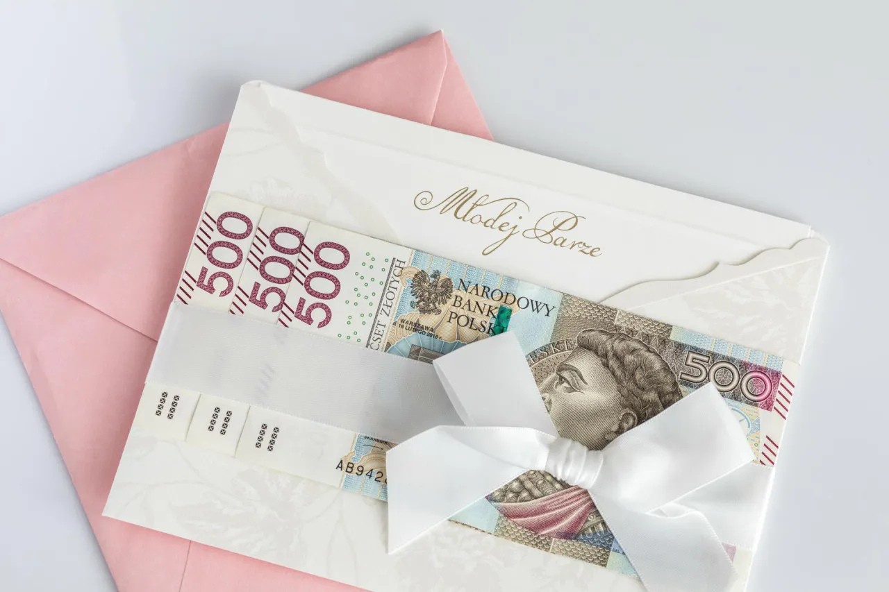 Młoda para liczy pieniądze z kopert ślubnych