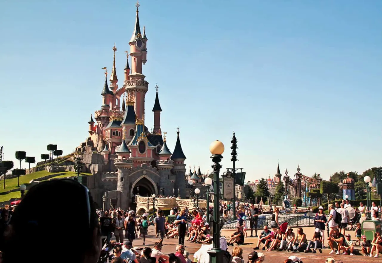 Zamek w Disneylandzie, tłumy ludzi czekają na atrakcje. Warto sprawdzić bilet Disneyland cena przed wyjazdem.