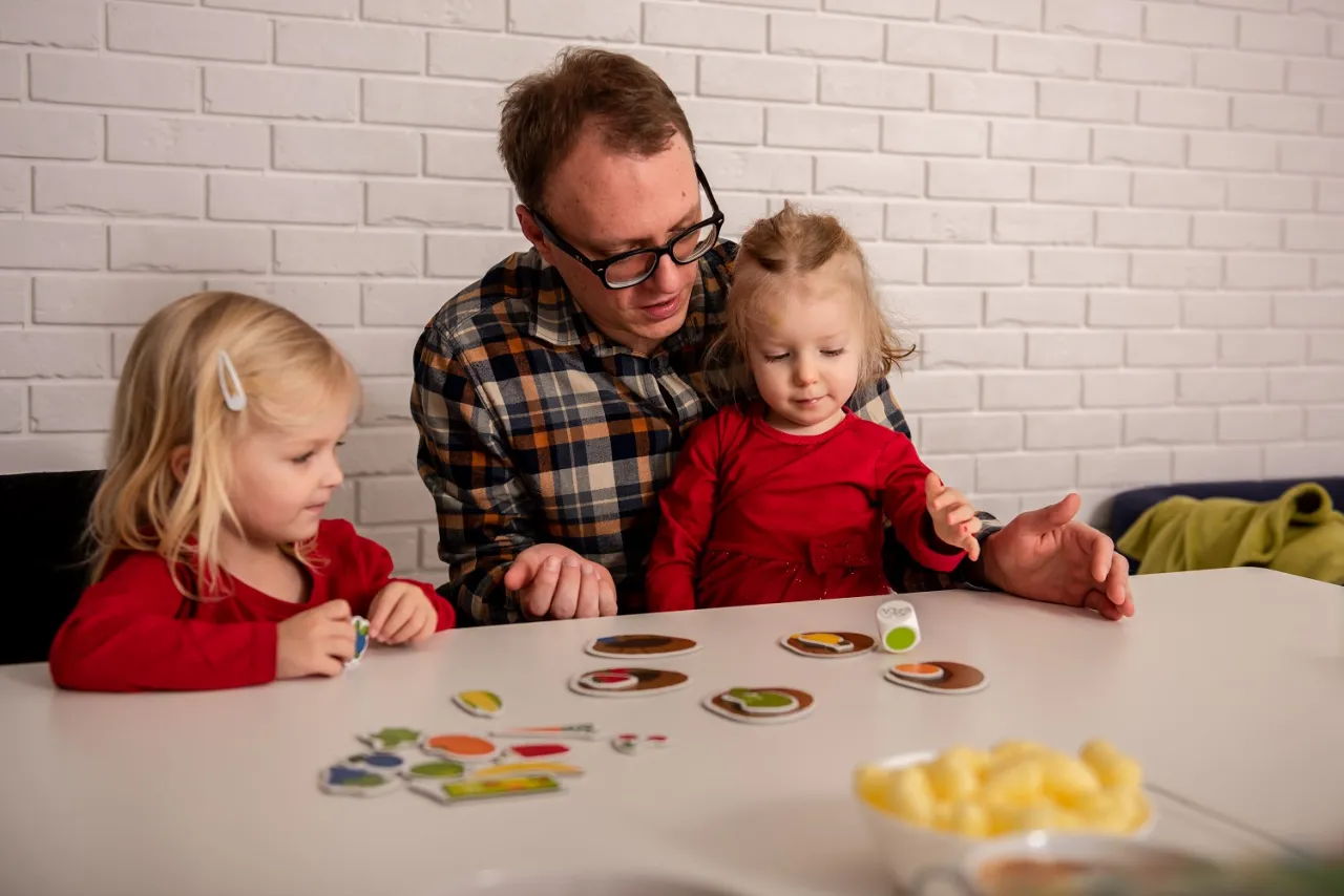 rodzic z dzieckiem wybierający grę planszową
