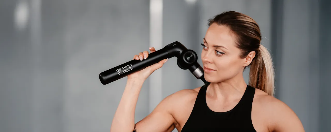 Kobieta z masażerem na wdowi garb, który pomaga rozluźnić napięte mięśnie karku i ramion.