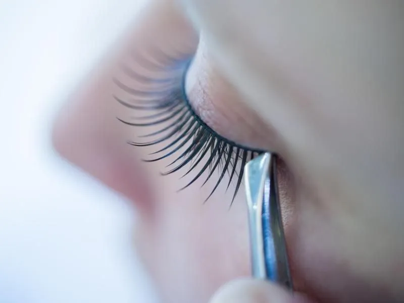 Reinigung von falschen Wimpern mit Pinzette und Wattepad