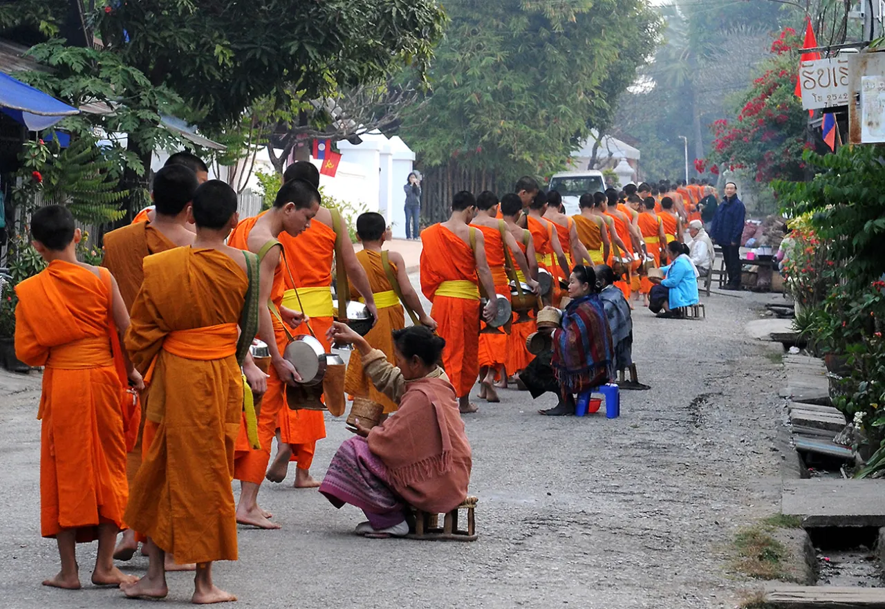 Mnisi w pomarańczowych szatach zbierają jałmużnę. Czy buddyści jedzą mięso? To zależy od tradycji i indywidualnych wyborów.