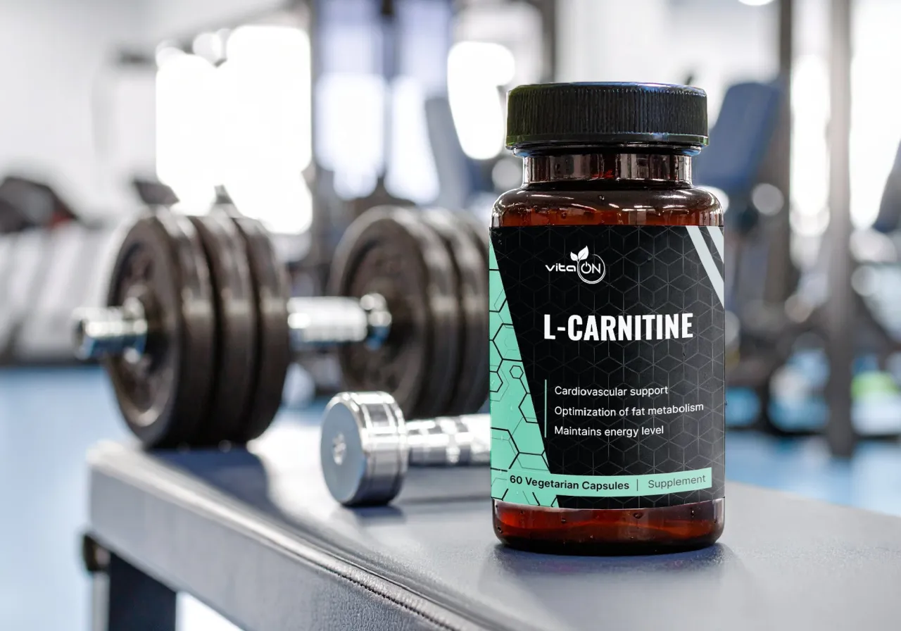 Butelka L-karnityny na ławce w siłowni, obok hantli. Sprawdź l-karnityna dawkowanie dla optymalizacji metabolizmu.