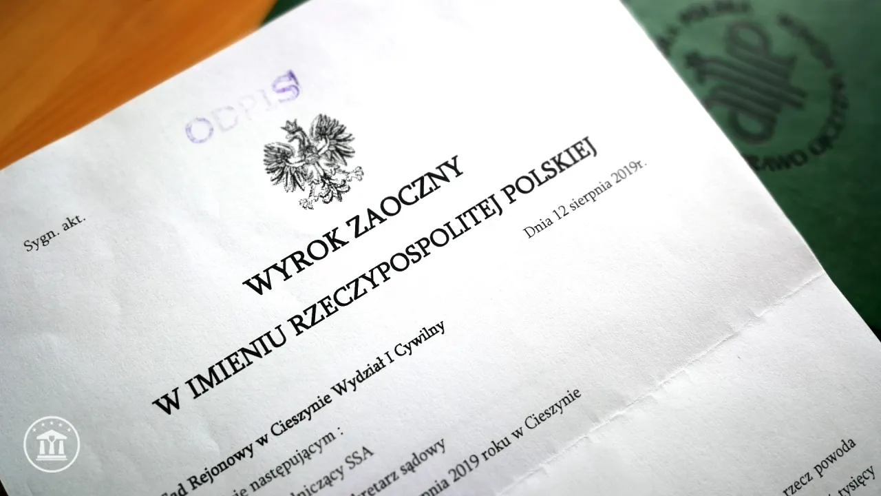 wyrok zaoczny, pieczęć sądowa, puste krzesło na sali sądowej