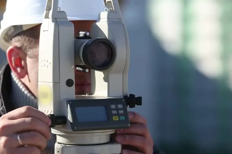 Geodeta sądowy w terenie z niwelatorem