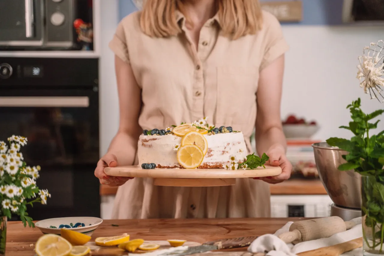 Uśmiechnięta kobieta piecze w kuchni, używając białek jaj