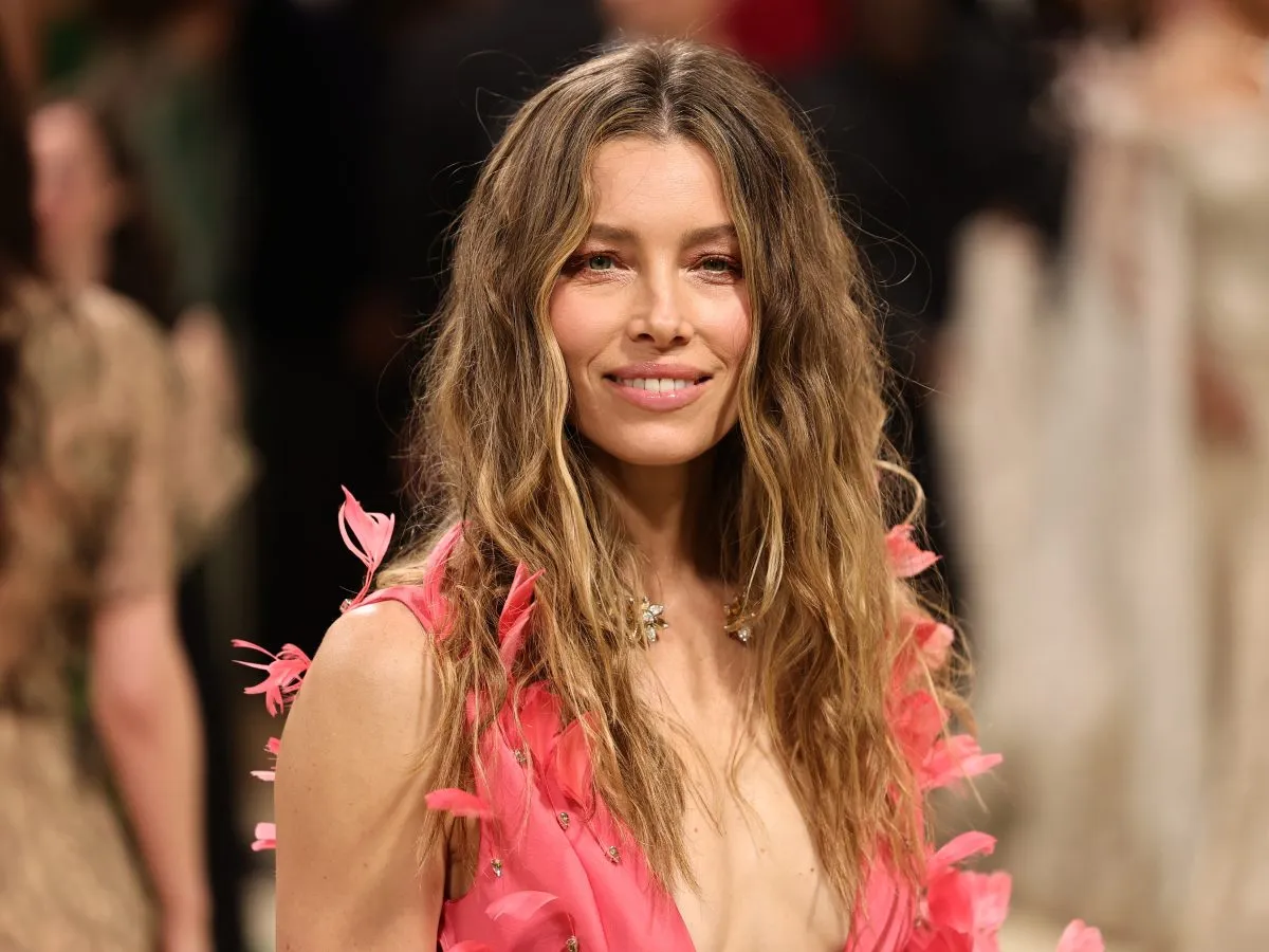 Uśmiechnięta Jessica Biel w r&oacute;żowej sukni z pi&oacute;rami, jakby na chłodne lato.