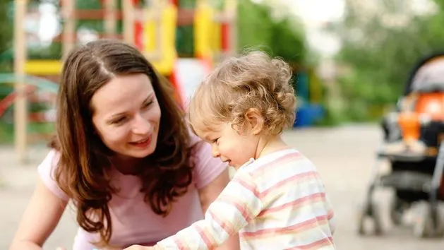 Rodzic z dzieckiem na placu zabaw bezpieczna zabawa