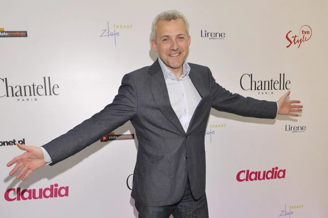 Uśmiechnięty mężczyzna w garniturze, jakby prowadził program 