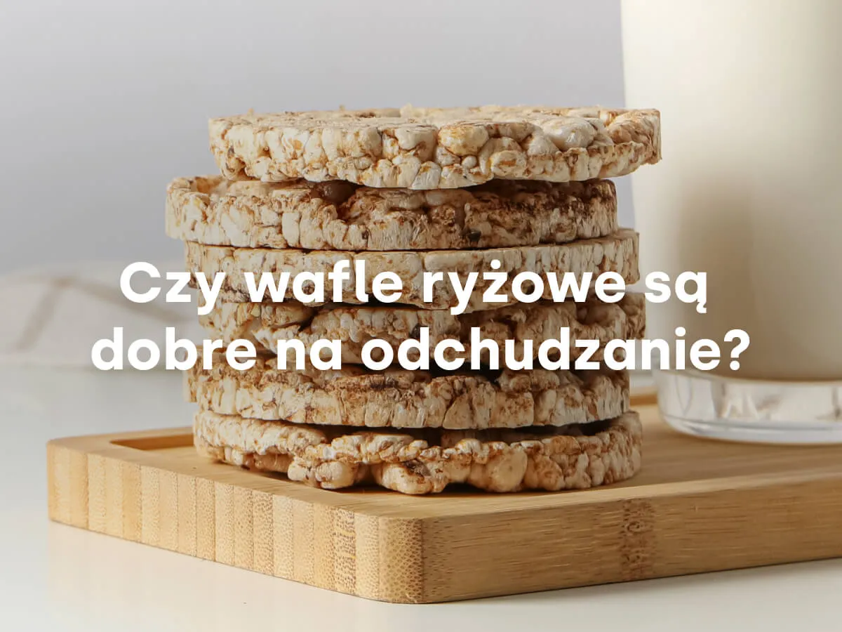 Stos chrupkich wafli ryżowych na drewnianej desce. Czy wafle ryżowe są zdrowe na odchudzanie? Obok szklanka mleka.