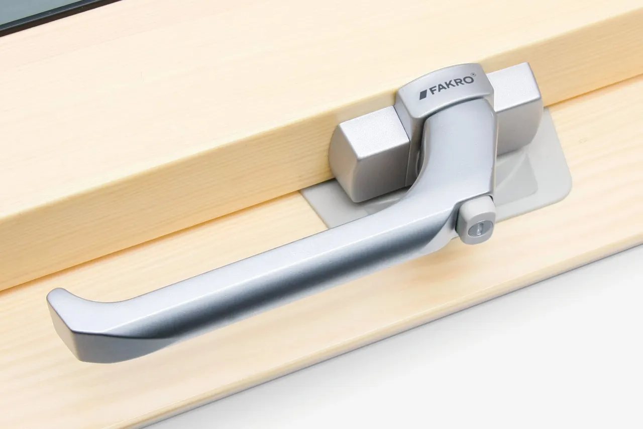 Eleganckie klamki do okien drewnianych Fakro, idealnie dopasowane do naturalnego drewna.