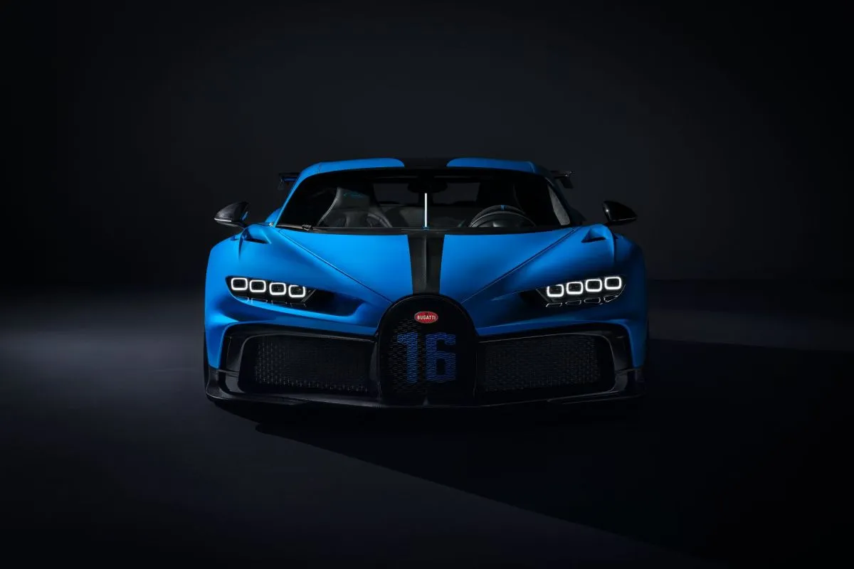 Niebieski Bugatti Chiron z czarnym pasem na masce. Zastanawiasz się, ile kosztuje Bugatti Chiron? To marzenie wielu kierowc&oacute;w.