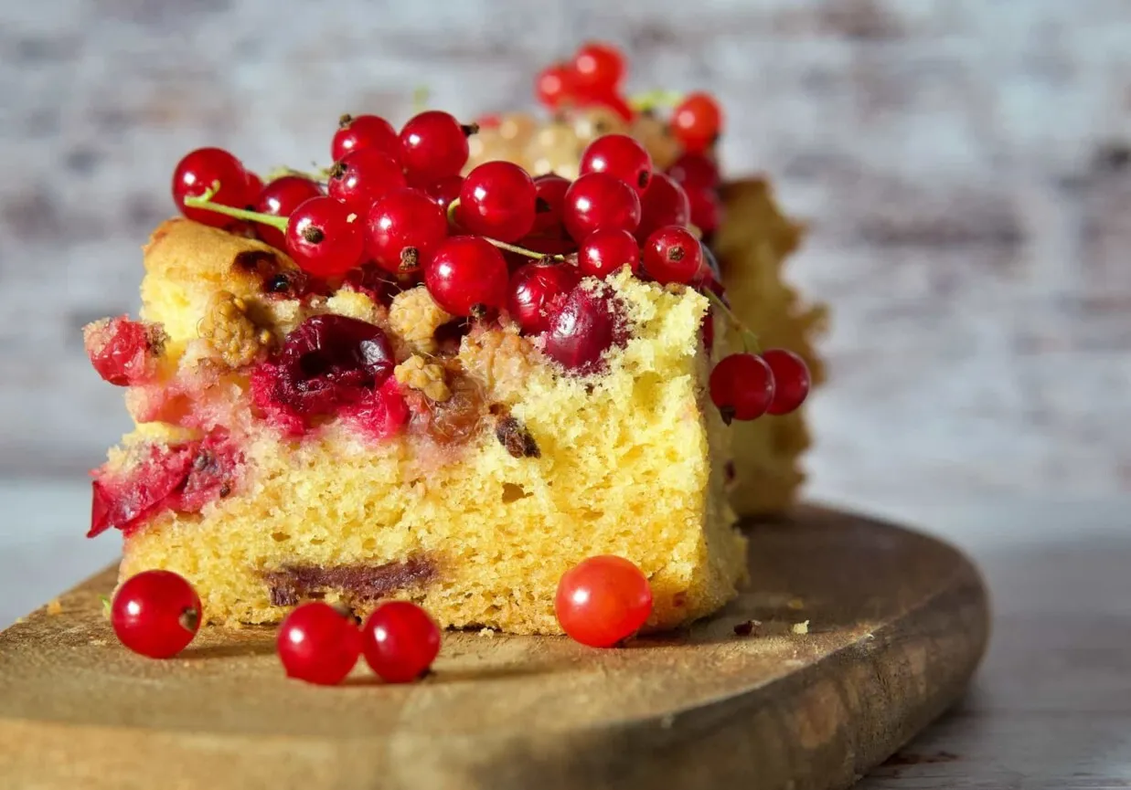 Pyszne ciasto drożdżowe z maszyny, ozdobione świeżymi czerwonymi porzeczkami. Idealne na letnie popołudnie.