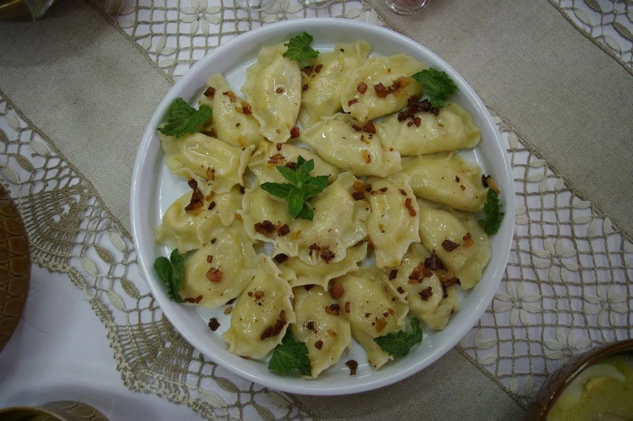 Talerz pełen pysznych pierog&oacute;w, polanych skwarkami i udekorowanych miętą. To prawdziwy catering jak u mamy, smak dzieciństwa na talerzu.