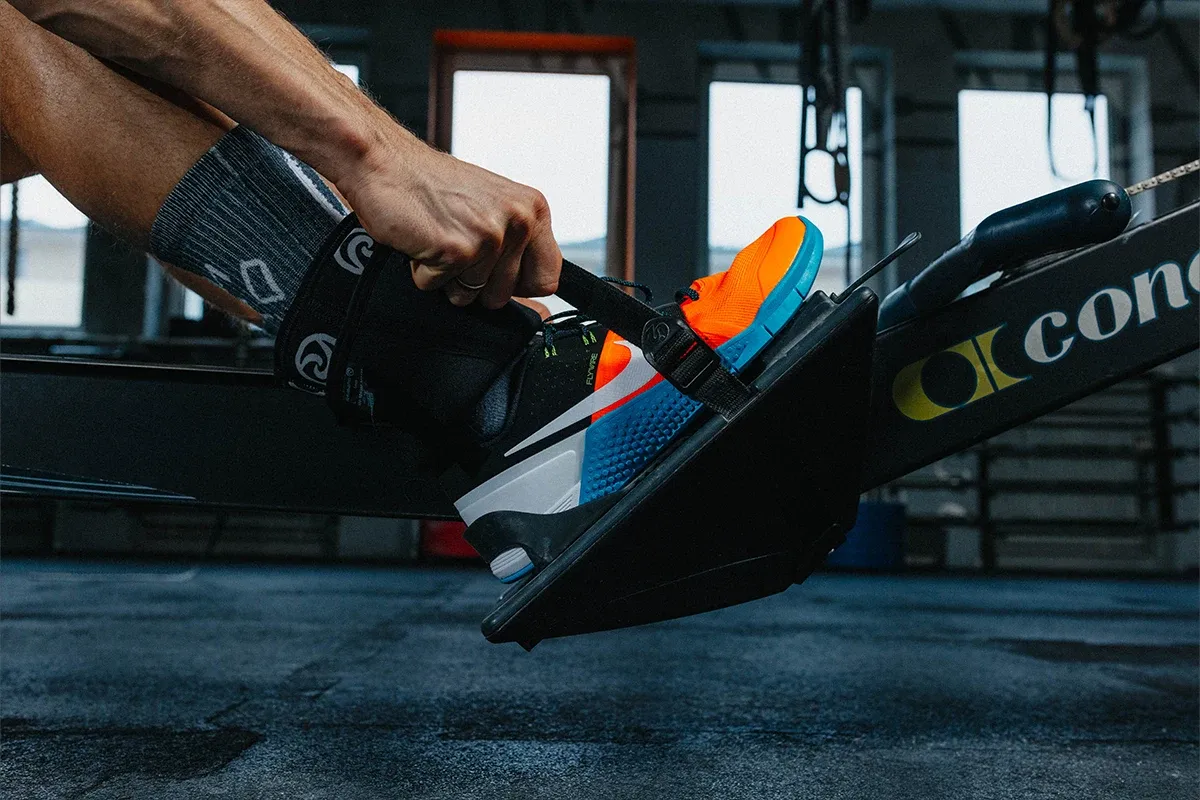 Wygodne buty do crossfitu w jaskrawych kolorach na wioślarzu.