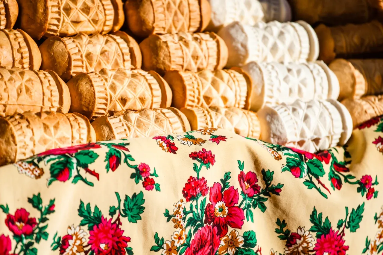 Oscypki i bundz z bac&oacute;wki w Białce Tatrzańskiej, ułożone na ludowym obrusie.