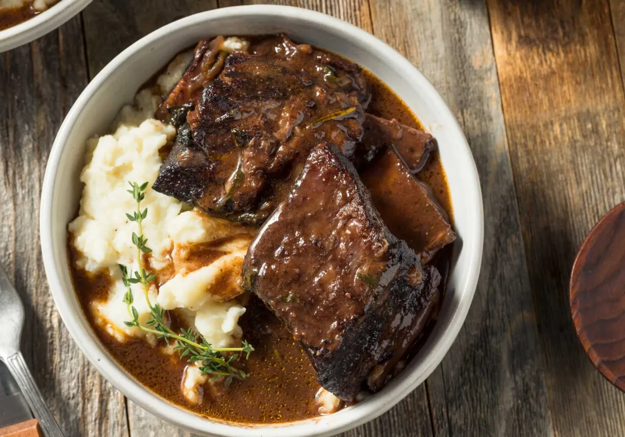 Pyszne, wolno gotowane żeberka w sosie własnym z puree ziemniaczanym. Idealny pomysł, co zrobić z ugotowanych żeberek, by zachwycić domownik&oacute;w.