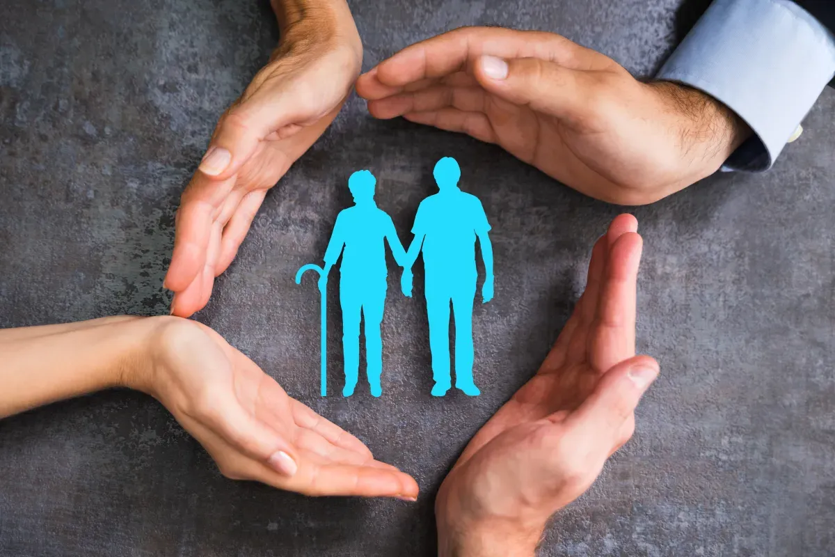 Ręce tworzą ochronny krąg wokół pary seniorów. Dowiedz się, jak uzyskać opiekę nad osobą starszą.