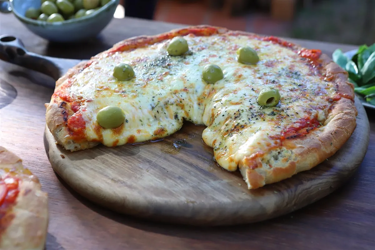Aut&eacute;ntica pizza argentina casera en un molde redondo con mucho queso
