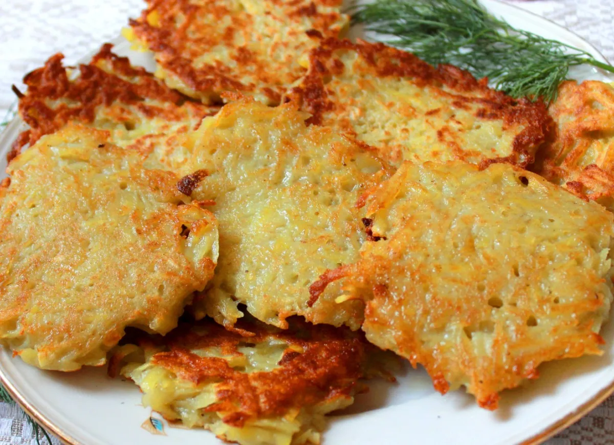 Placki ziemniaczane: słodkie z cukrem czy słone ze śmietaną? Złociste, chrupiące placki ziemniaczane na talerzu.