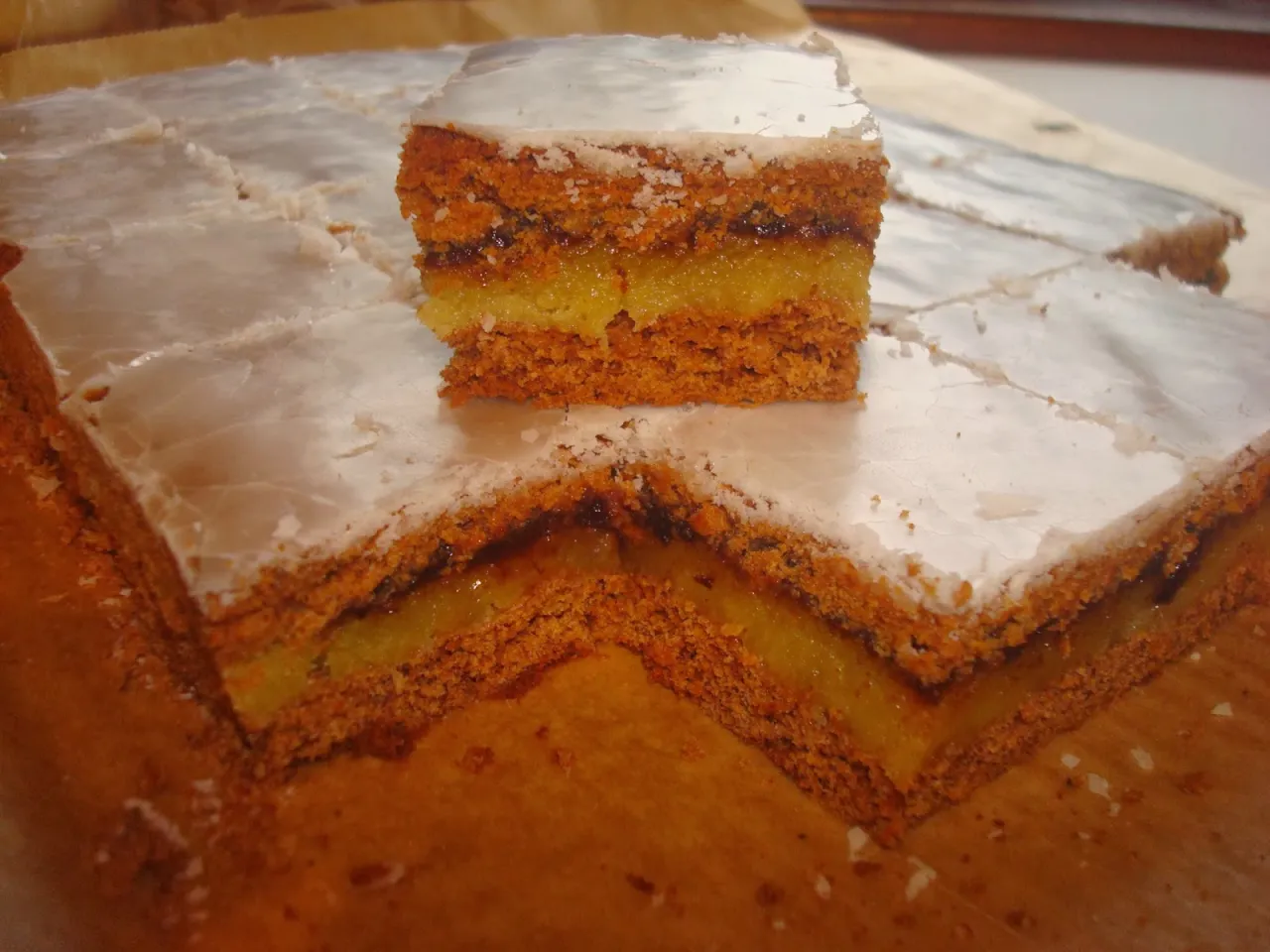 Krajanka z marmoladą, pyszne ciasto z przepisu. Warstwy piernika przełożone dżemem i polane lukrem.