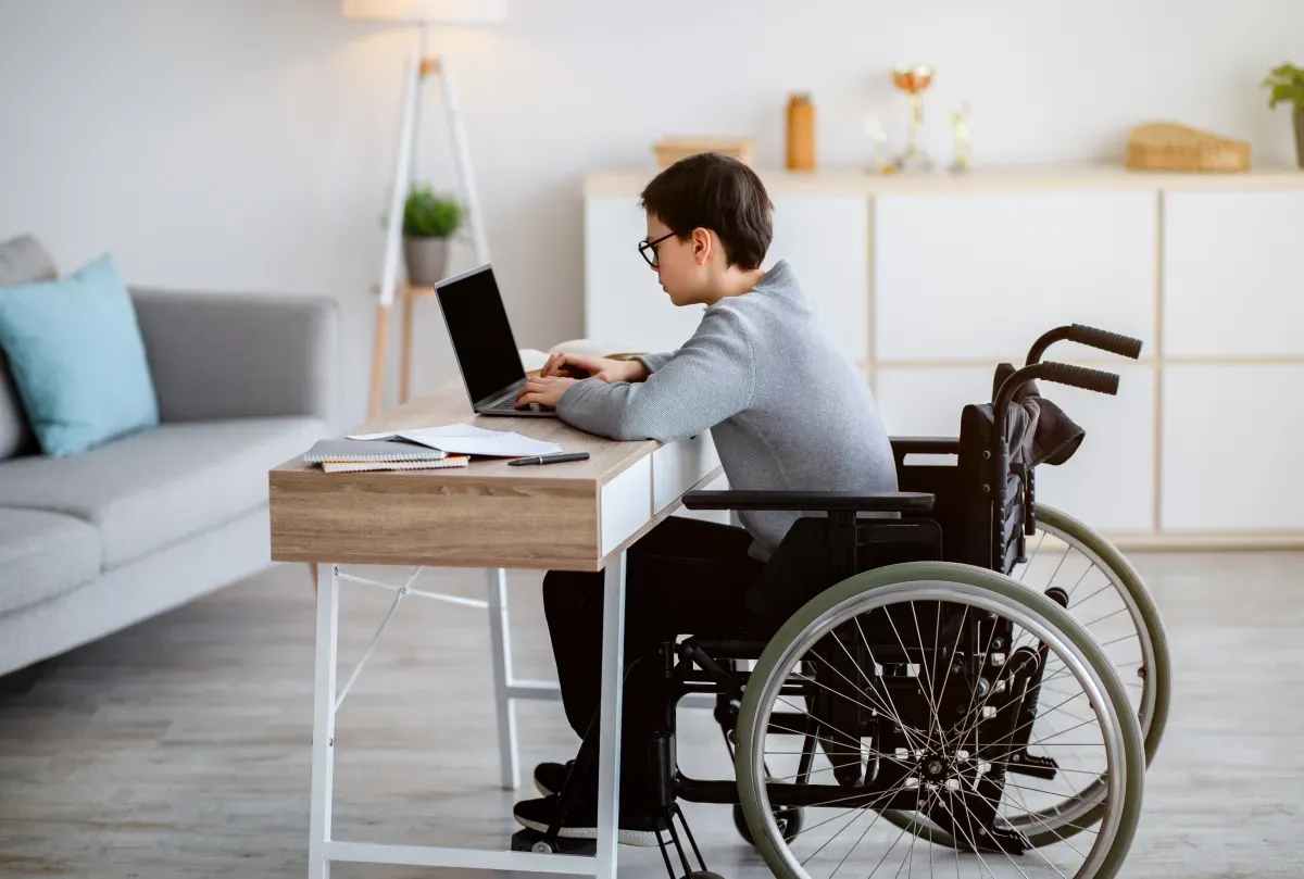 Rodzic wypełniający wniosek online o dofinansowanie na laptopa