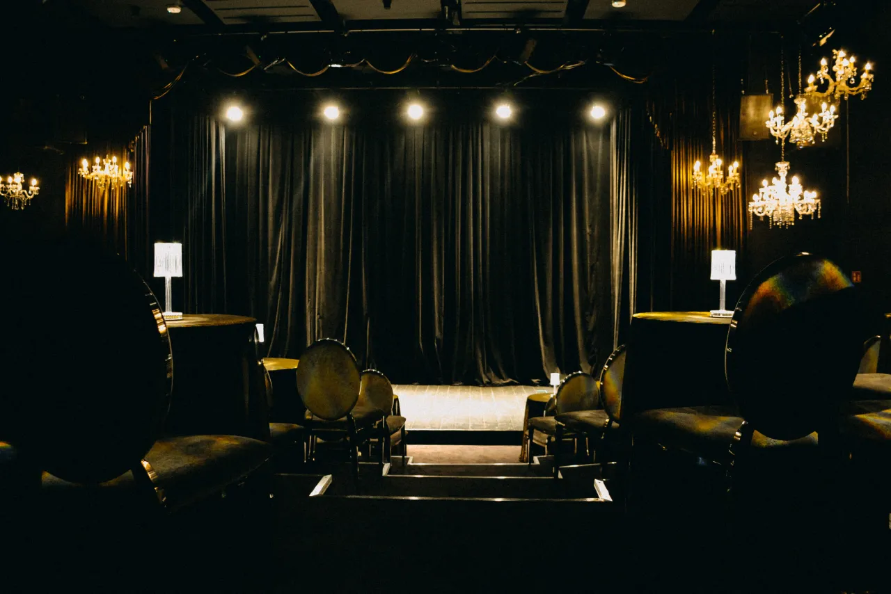 Kameralna scena z welurowymi zasłonami, żyrandolami i pustymi miejscami. Takie teatry w Warszawie czekają na widz&oacute;w.