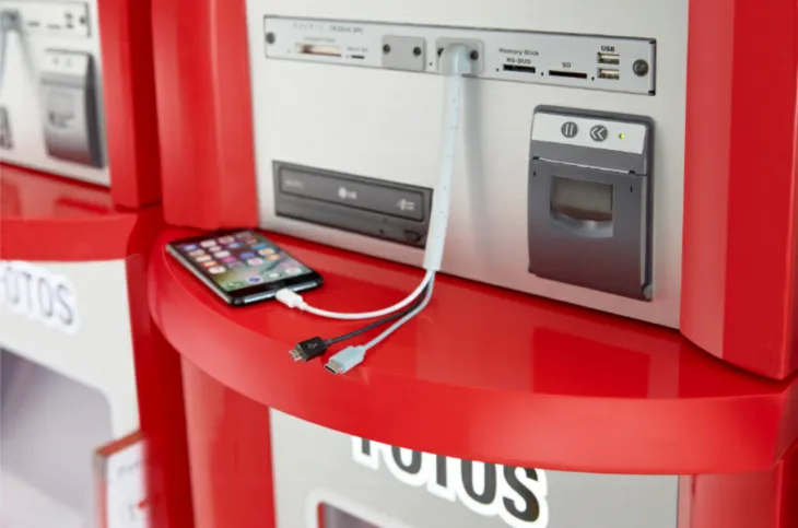 osoba wywołująca zdjęcia z telefonu w fotolabie, kiosk fotograficzny