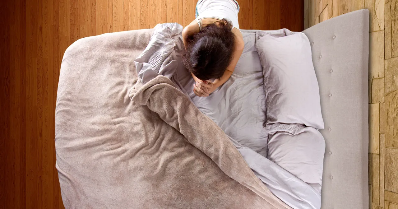 Osoba starsza chora w łóżku ogląda mszę w telewizji