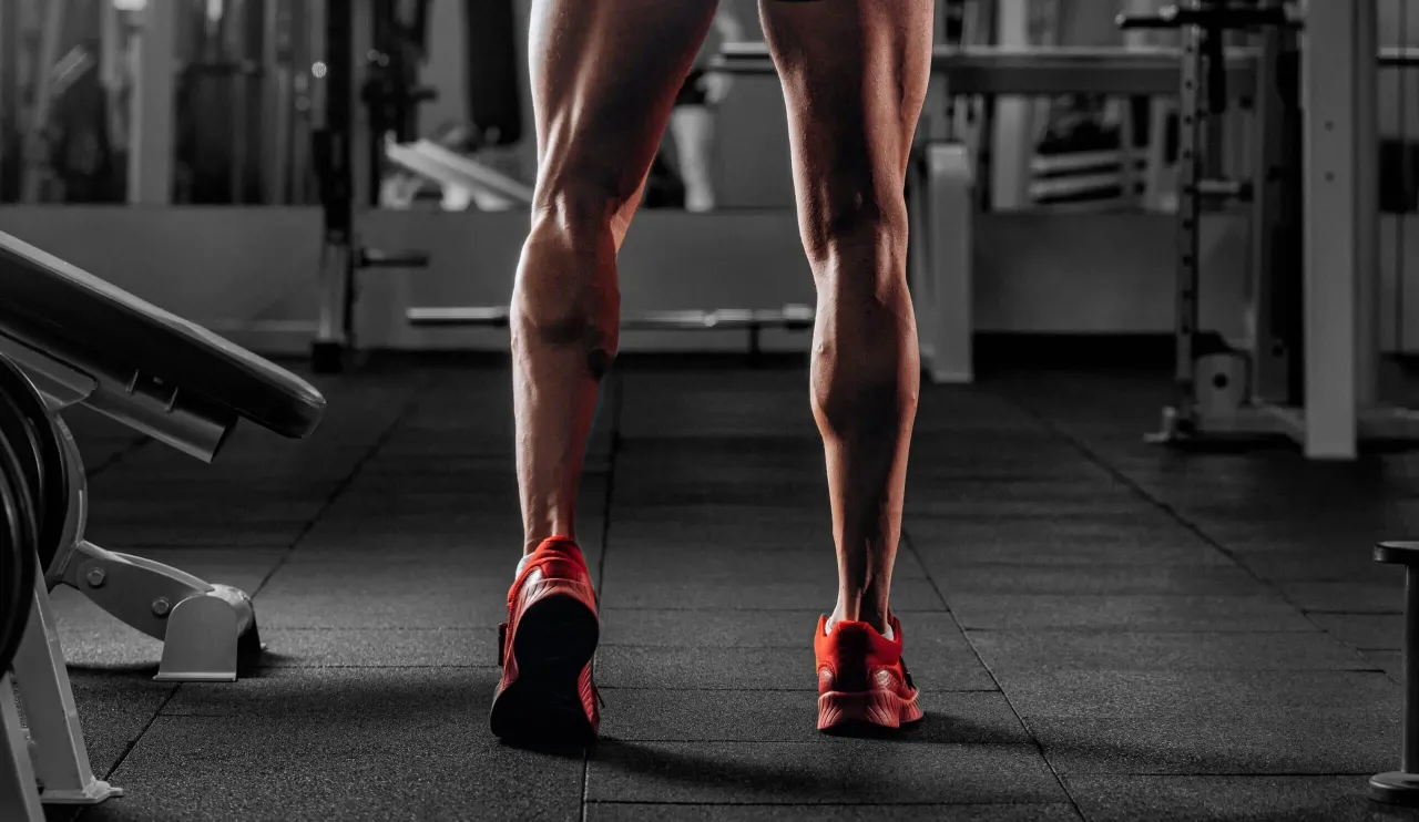 Mięśnie łydek w czerwonych butach. Szukasz inspiracji, jakie ćwiczenia na łydki wybrać, by osiągnąć taki efekt?