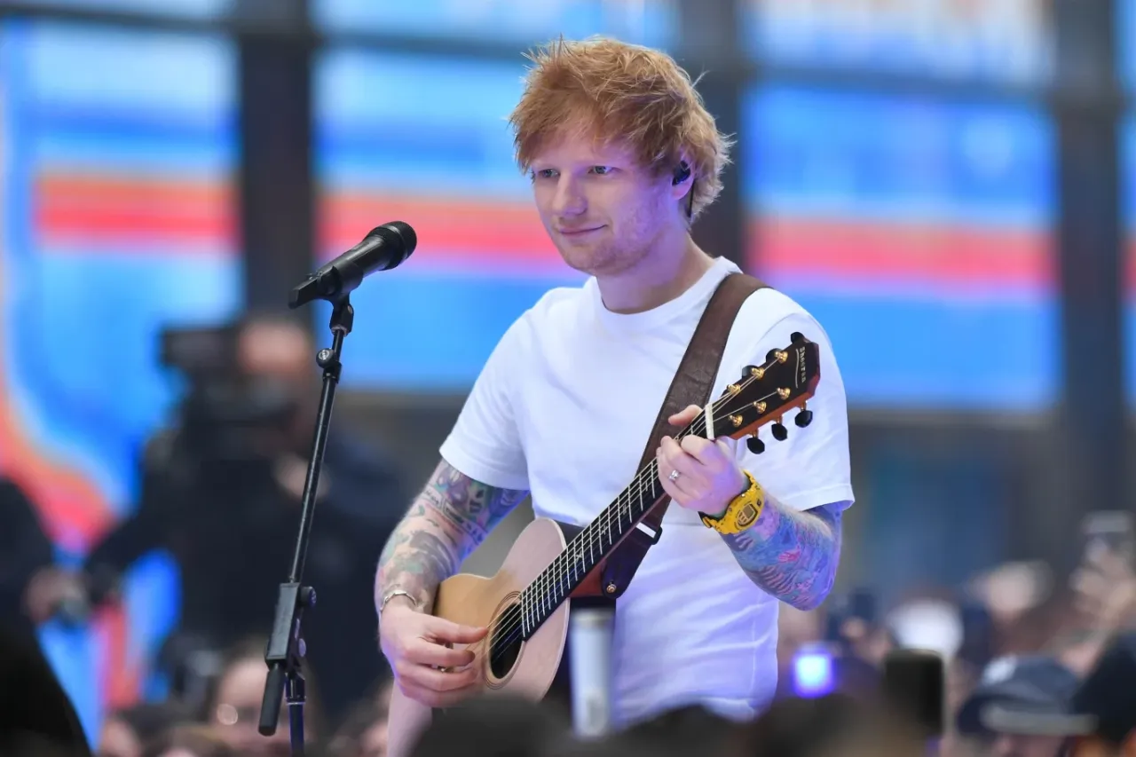 Ed Sheeran gra na gitarze podczas koncertu. Zastanawiasz się, ile Ed Sheeran bierze za koncert?