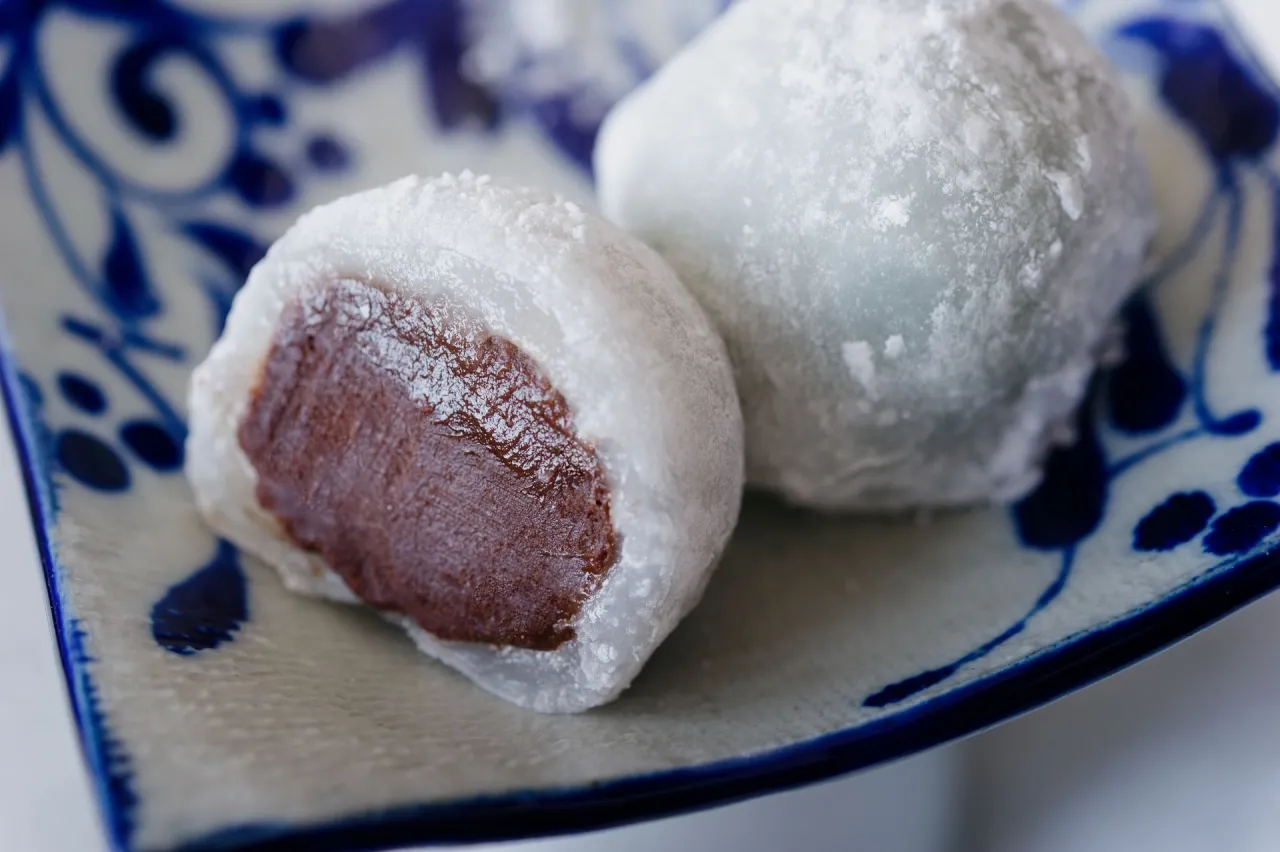 Słodkie mochi z nadzieniem czekoladowym, posypane mąką ziemniaczaną. Idealne do domowego przepisu na mochi.