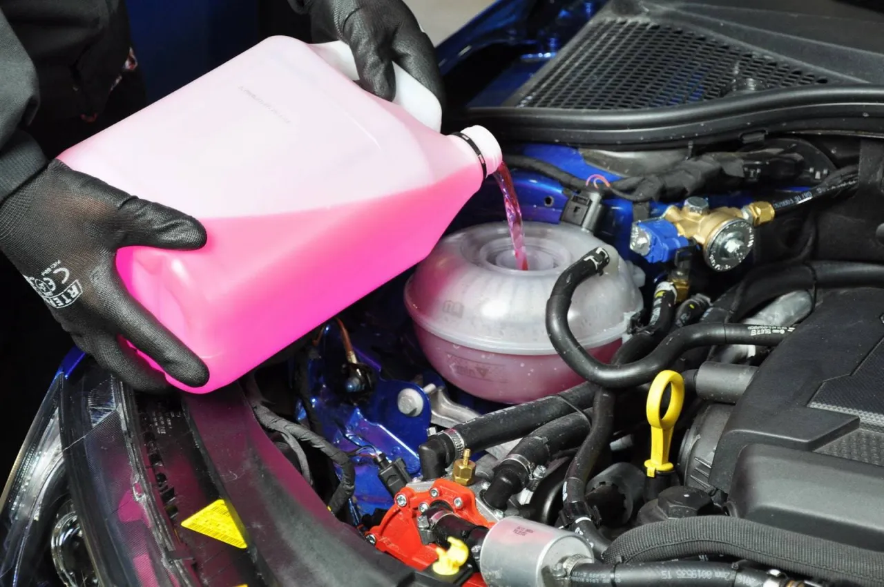 Pod maską samochodu 96 widać, co można znaleźć pod maską: płyn chłodniczy wlewa się do zbiorniczka.