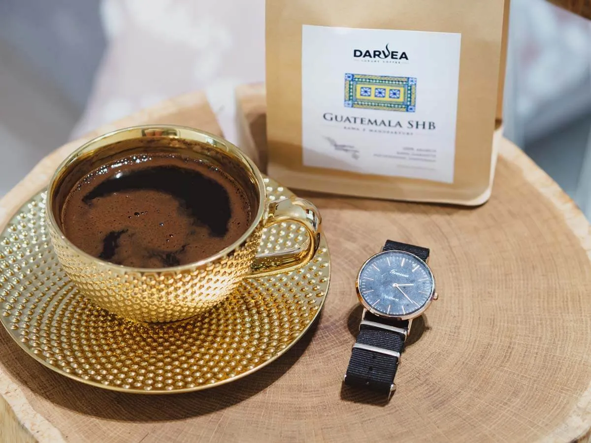 Osoba pijąca kawę i kakao, z zegarem w tle