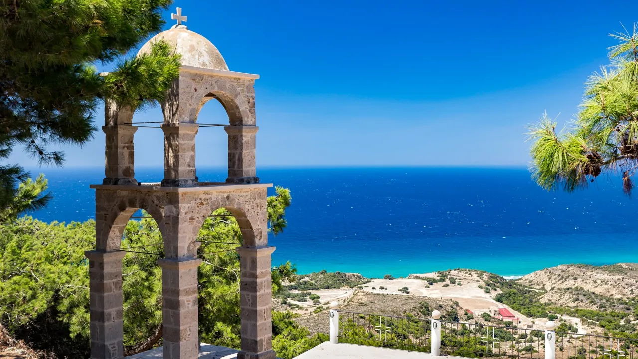 Kamienna dzwonnica z widokiem na turkusowe morze. Idealne miejsce, by zacząć planować, co zwiedzić na Kos.