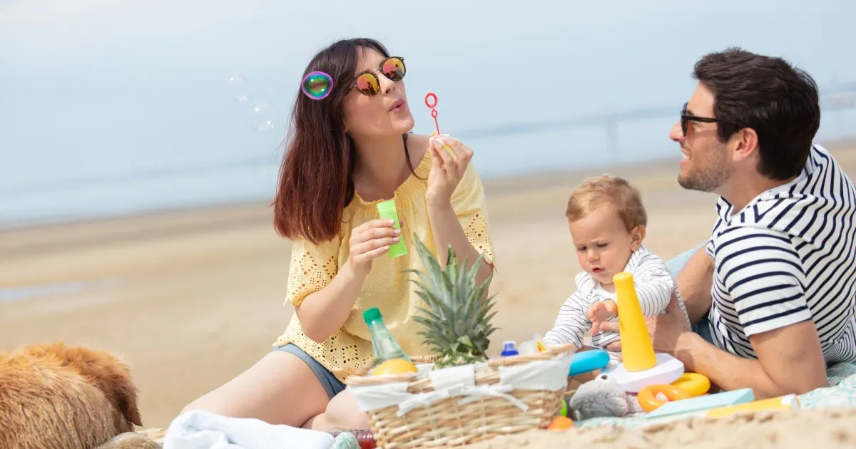 Rodzina z rocznym dzieckiem na plaży w Polsce, bezpieczne wakacje