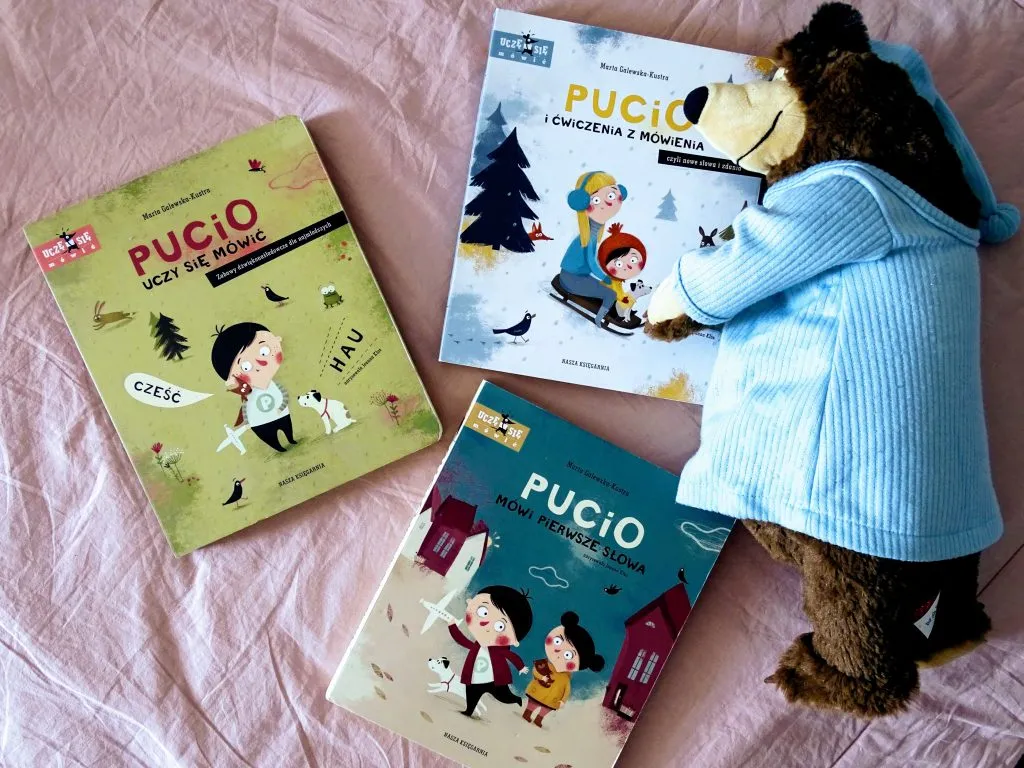 rodzice bawiący się z dzieckiem w grę słowną przy użyciu książki