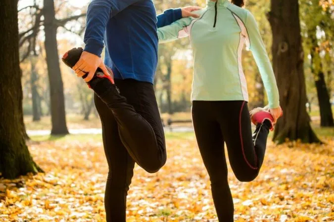 osoba rozgrzewająca się przed biegiem