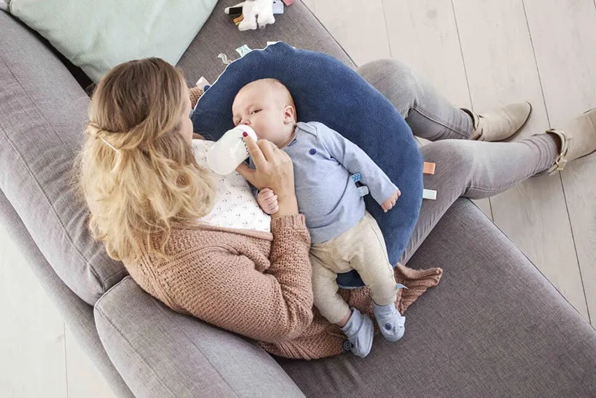 rodzic karmiący dziecko na poduszce do karmienia