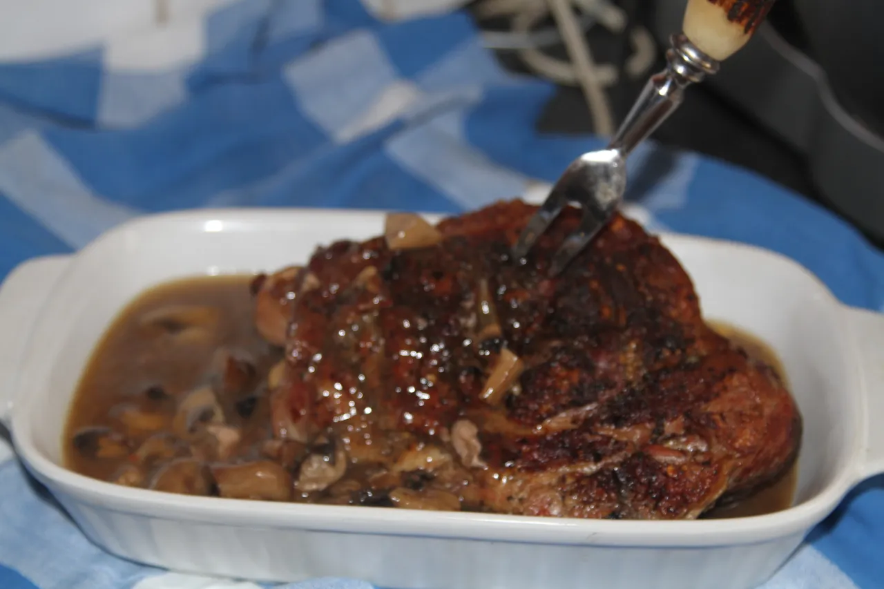 Soczysta biodrówka wieprzowa w sosie z grzybami, idealna na obiad. Widelec już czeka, by spróbować to pyszne danie.