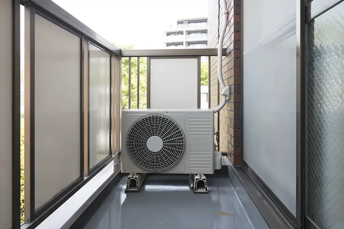 Jednostka zewnętrzna klimatyzacji na balkonie. Dowiedz się, jak zamontować klimatyzację w bloku, by cieszyć się chłodem.
