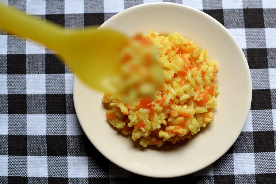 Talerz z kleikiem ryżowym i gotowaną marchewką dla dziecka