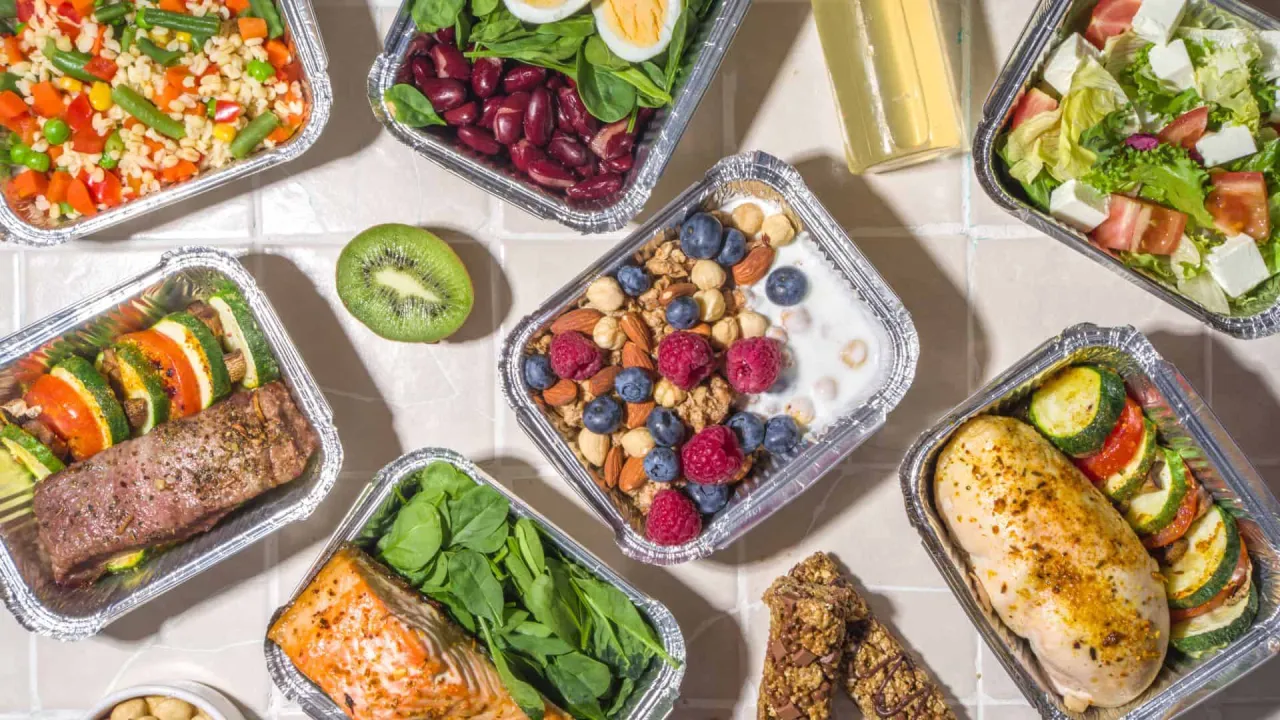 R&oacute;żnorodne posiłki w pojemnikach: łosoś, kurczak, stek, sałatka, owsianka z owocami. Zastanawiasz się, ile kosztuje catering dietetyczny?